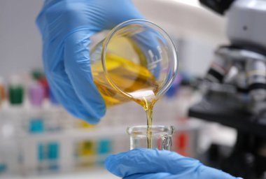 Kimyasalları karıştırıp döküyorum. Laboratuvar ve bilimsel deneyler. Tıbbi araştırmalar için kimyasalların petrol formülü.