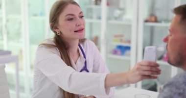 Kadın doktor kan alkol seviyesini ölçmek için hastaya alkol ölçer veriyor. Hastanın ağır çekimde muayene odasında test edildiği görüntüler.