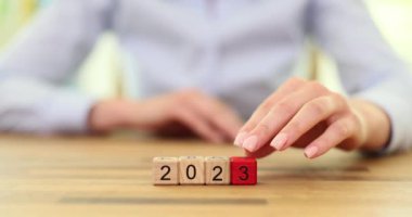 Dişi el, tahta küplerden tarih yaratır ve 2024 'ü oluşturan sayıyı 3' ten 4 'e değiştirir. Yeni yıl tatili için hazırlık kavramı yavaş çekim