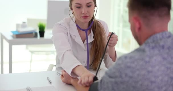 在医院检查期间 医生办公室的护士用血压计测量男性病人的血压 病人每月在医院接受检查 — 图库视频影像