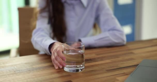 Eine Mitarbeiterin Hält Ein Glas Wasser Auf Einem Holztisch Und — Stockvideo