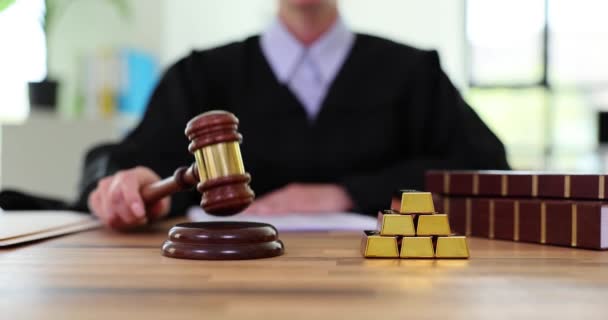 Női Bíró Döngeti Kalapácsot Tárgyalóasztalon Egy Halom Aranyrúd Korrupció Bizonyítékaként — Stock videók
