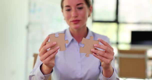ブラウスの女性幹部が 大きなパズルをまとめました 仕事の遅い動きでパズルをまとめる自信を持った性格のマネージャー — ストック動画