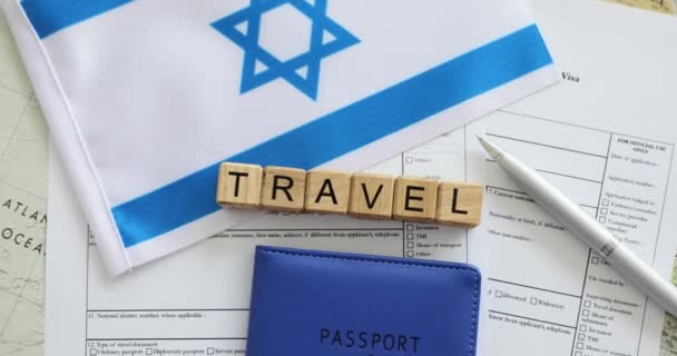 ビザを受け取るための形式上の国際パスポートと旗 観光代理店による休日の準備の概念 木製ブロックの横にあるイスラエルの国旗 — ストック動画