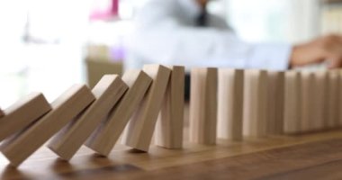 Tişörtlü erkek girişimci, kırmızı domino taşırken beyaz domino taşlarını durdurur. Takım ruhunda liderlik rolünün önemi kavramı