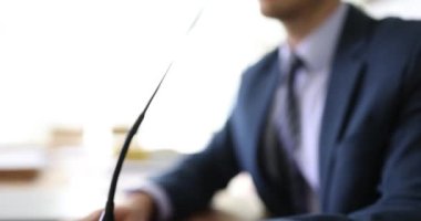 Şirket yönetim kurulu toplantısında iş adamı mikrofona konuşuyor. Erkek müdür şirket ofisinde ağır çekimde el kol hareketleri yapıyor ve konuşuyor.