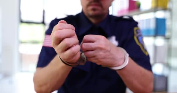 Mężczyzna Policjant Mundurze Zdejmuje Kajdanki Siedząc Przy Stole Biurze Pojęcie — Wideo stockowe