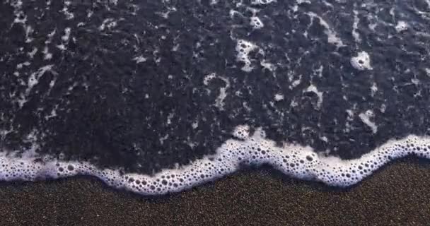 Dluh Napsaný Mokrém Černém Písku Pláži Soumraku Pěnící Oceánské Vlny — Stock video