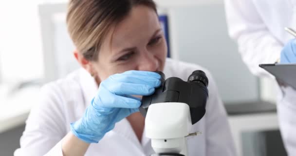在实验室4K电影中 女生物学家通过显微镜观察 生物教育概念 — 图库视频影像