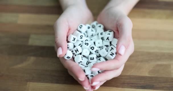 女性の手の白いプラスチックキューブ上のアルファベットの多くのシンボル 創造性とコンセプトを読むことを学ぶ — ストック動画