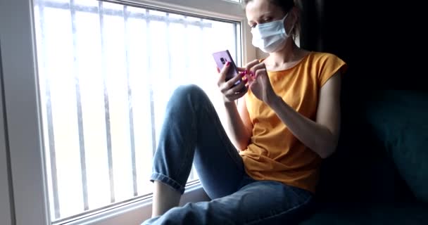Mujer Joven Máscara Protectora Sentado Con Teléfono Sus Manos Cerca — Vídeo de stock