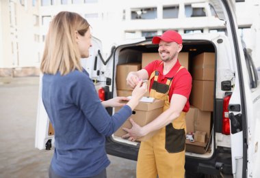 Erkek kurye paketin alınması için müşteri makbuzunu verir. Teslimat ve paketler ve posta kavramı