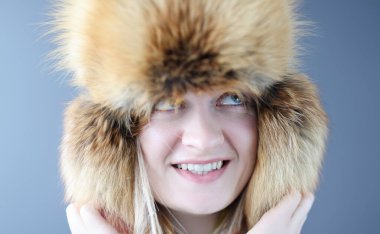 Sıcak şapkalı genç bir kadının portresi. Kürk ürünleri konsepti satışı