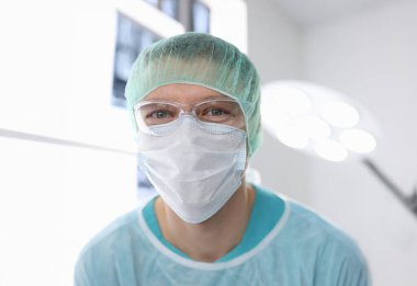 Ameliyathanede ameliyat kıyafeti giymiş erkek doktorun portresi. Estetik ameliyat konsepti
