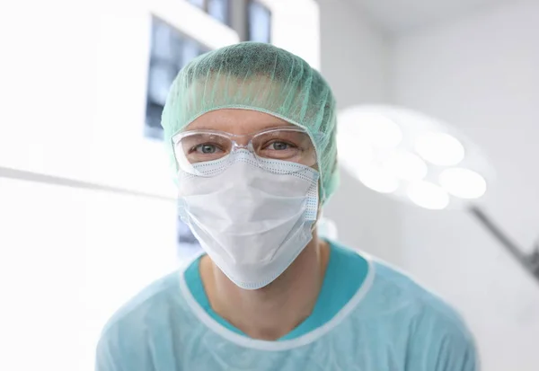 Portrait of male doctor in surgical suit in operating room. Plastic surgery concept