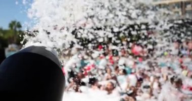 Köpük partisi ve arkasında turistler olan siyah köpük topu. Turistler için eğlence