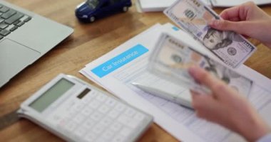 Araba sigortası belgeleri üzerinde çalışan bir iş kadını. Otomobil sigortası ve dolar faturası