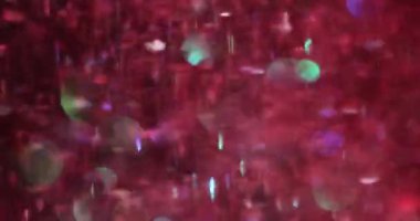 Kırmızı parlak Noel desenli soyut şenlik arkaplanı. Arka planda parlak pembe parıltılar uçuşuyor.