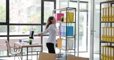 Ofisteki iş görüşmesinden sonra kutlama yapan mutlu iş kadını. Genç iş kadını ellerini kaldırıp dans ediyor.