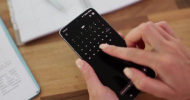 Cep telefonunda takvim uygulaması kullanan bir kadının yakın çekimi. Akıllı telefondaki takvim ekranı boyunca kaydırılıyor