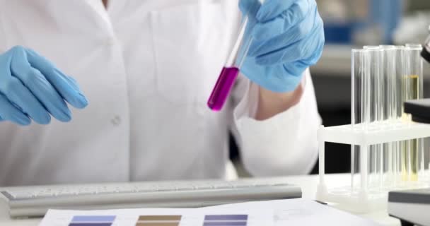 女化学家检查液体的酸度并记录数据4K片 制药业的创新概念 — 图库视频影像