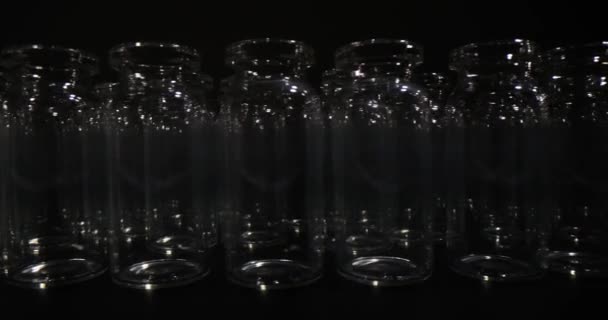 一排排空玻璃瓶 用于黑色背景的疫苗生产和包装 医疗及化验用专业玻璃器皿 — 图库视频影像