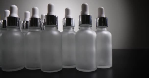 灰色の背景にクリームと血清のための白いガラス化粧品瓶のセット 化粧品用ボトル — ストック動画