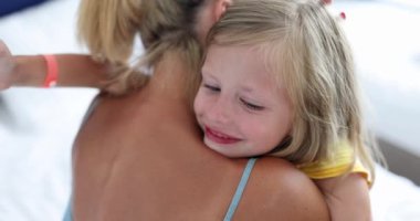Annem, 4K filminde ağlayan küçük bir kızı rahatlatıyor ve kucaklıyor. Çocuk kavramının psikolojik sorunlarında ebeveynlere destek
