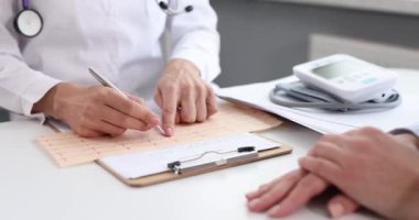 Doktor elleri kardiyogram ve hasta sonuçlarını tutuyor. Kardiyovasküler sistem kavramı araştırılıyor