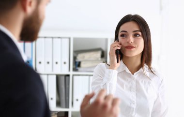 Ofis portre işkadını konuşma cep telefonu gülümseyen güzel esmer. Kalış temas pazarlık toplantı iş beyaz yakalı yoğun yaşam tarzı elektronik cihaz mağaza mesleki eğitim konsepti
