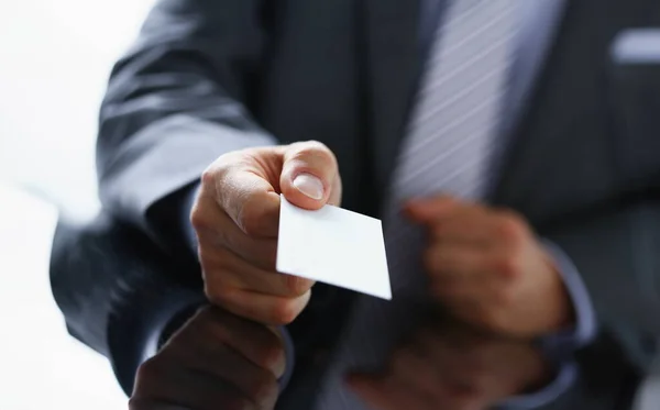 Male arm in suit give blank calling card to visitor closeup. White collar colleagues company name exchange job interview sale clerk id, executive or ceo finance support formal identity concept