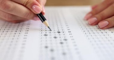 Student solving tests and crossing out correct answers with pencil on paper closeup 4k movie slow motion. Exam testing concept