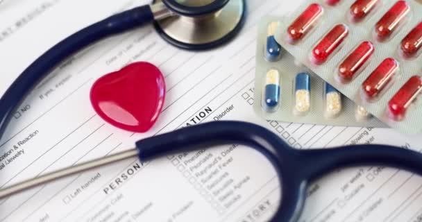 Coração Brinquedo Vermelho Estetoscópio Deitado Documentos Médicos Com Medicamentos Closeup — Vídeo de Stock