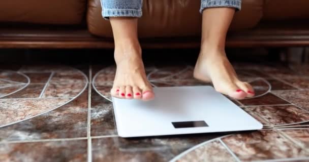 ホームクローズアップ4K映画スローモーションで床の電子スケールに立つ女性の足 体重管理の概念 — ストック動画