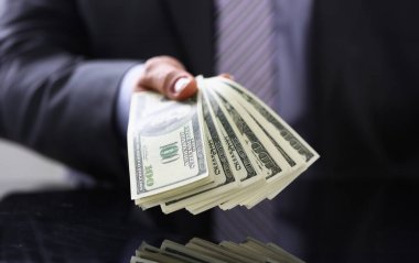 Erkek takım elbise ve kravat tutun yüz dolar faturaları closeup kol paket içinde. Borsa döviz kazanmak kazık zengin mevcut hediye işveren ön ödeme hizmeti Şükran kavramı