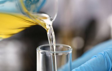 Motor yağı otomatik vites ve hidrolik yükseltici kimya test tüp elinde üretir koruyucu eldiven erkek el ele tutuşur