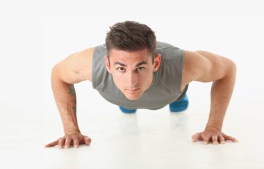 Zeminden fırlayan fitness adamı beyaz arka planda izole edilmiş iyi fiziksel egzersizler gösteriyor. Birçok insan için sağlıklı bir yaşam tarzı. Her gün kaybettikleri için kendi ağırlıklarını koyuyorlar..