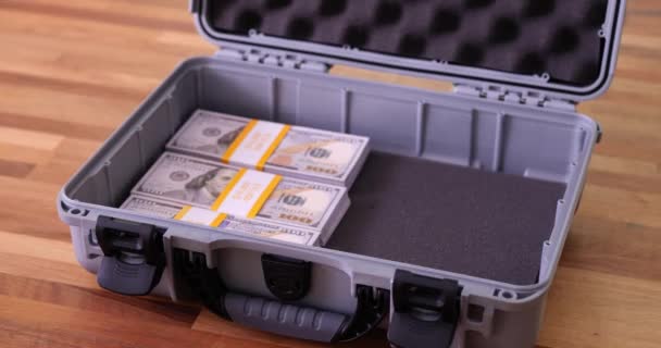 许多堆积如山的美元钞票上的手铐 在装满钱和成堆的钱的手提箱里 — 图库视频影像