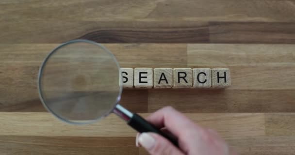 在有放大镜的木制立方体上搜寻单词 寻找信息 创意和生命的意义 — 图库视频影像