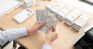 İş kadını ya 100 dolarlık banknotları sayar ya da nakit para öder. Yatırım ve başarı kavramı