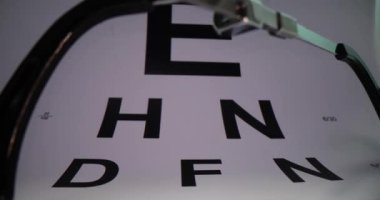 Gözlükler görüş test masasının arka planında, yakın plan. Uzaklık, miyopluk ve astigmatizm.