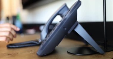 Telefon masasındaki düğmeye elle basan adam işaret ediyor. Çalışanların çoklu görev konsepti