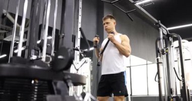 Adam spor salonunda çalışıyor ve spor salonunda ağırlık kaldırıyor. Spor salonunda Latissimus kas makinesi