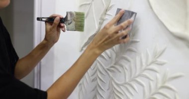 Beyaz akriliklerle soyut duvar resmi. Yaprakları ve tasarımcısı olan klasik grunge doku duvarı resim çizer