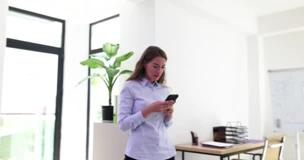 Счастливая Женщина Пользуется Телефоном Просматривает Приложения Ходит Офису Улыбающаяся Уверенная — стоковое видео