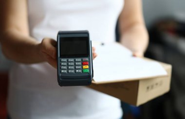 Teslimat servisine yakın çekim ve hızlı ödeme için kasiyer makinesi. NFC teknoloji sayacı. İmza için panosu olan kişi. İstemci aktarım faturasını terminal üzerinden öder