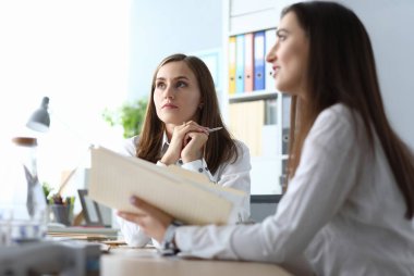 Modern iş yerinde oturan ve konsantrasyonu olan birini dinleyen zeki iş adamlarının portresi. Dosyaları ve grafikleri olan harika bir kadın. Muhasebe ofisi kavramı