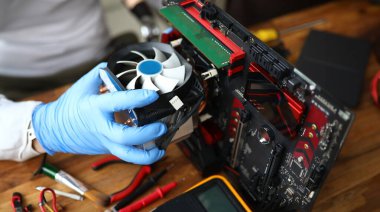 Cihazın detaylarını tamir eden orta yaşlı bir adama yakın plan. Teknisyen erkek, ana bilgisayarı tamir ediyor. Araçlar çalışma masasının üzerinde. Teknoloji ve ölüm konsepti.