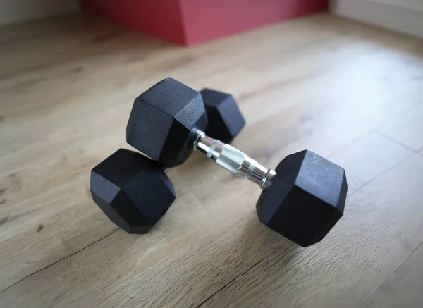 Close-up of metal heavy dumbbells for training home. Sport equipment for fit strong body. Fitness instrument on floor. Athlete and exercises indoors on quarantine concept