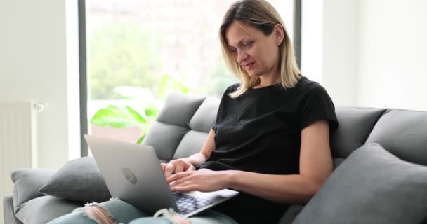Lachende Jonge Vrouw Zittend Bank Met Een Laptop Kijkend Naar — Stockvideo